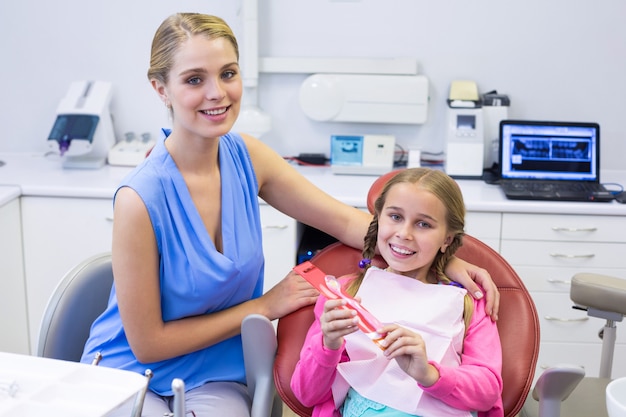 Madre e hija sonrientes en la clínica dental