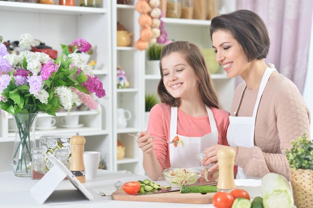 Madre e hija sonrientes cocinando juntas en la cocina