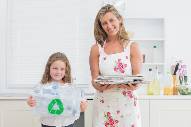 Madre e hija sosteniendo la basura