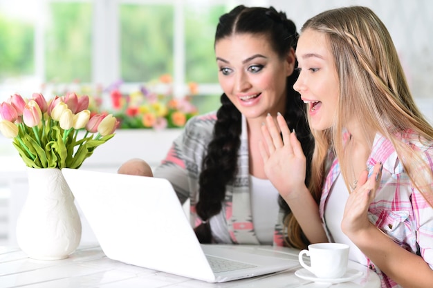 Madre e hija usando la computadora portátil