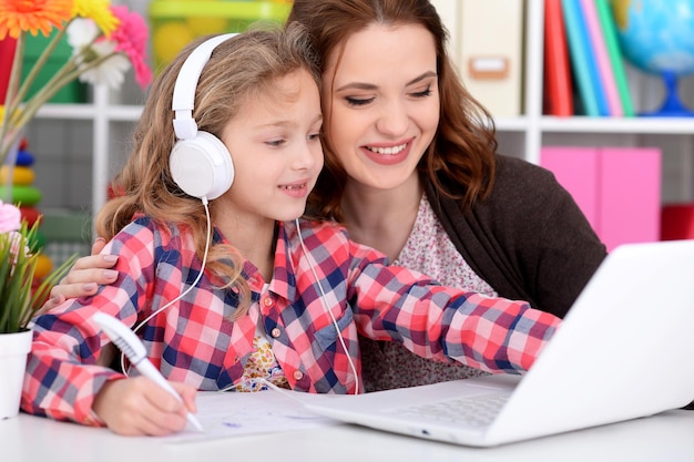 Madre e hija usando laptop juntos