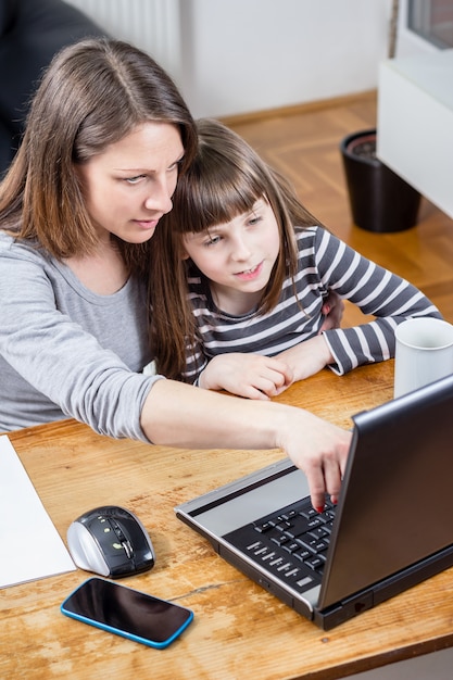 Madre e hija usando laptop