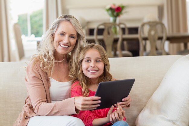 Madre e hija usando tableta digital en casa