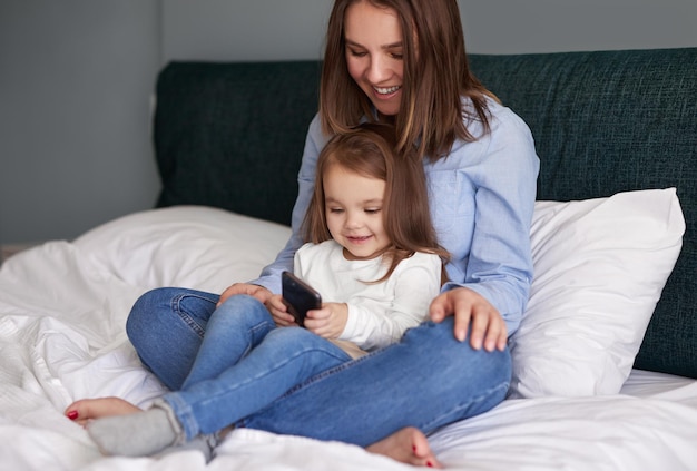 Madre e hija usando un teléfono inteligente juntos