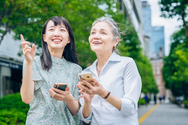 Madre e hija usando teléfonos inteligentes