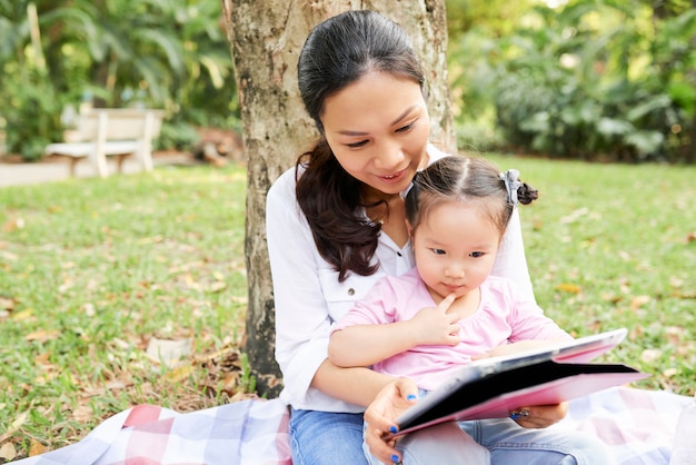 Madre e hija viendo dibujos animados al aire libre