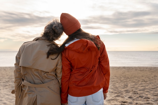 Foto madre e hija en la vista trasera de la playa