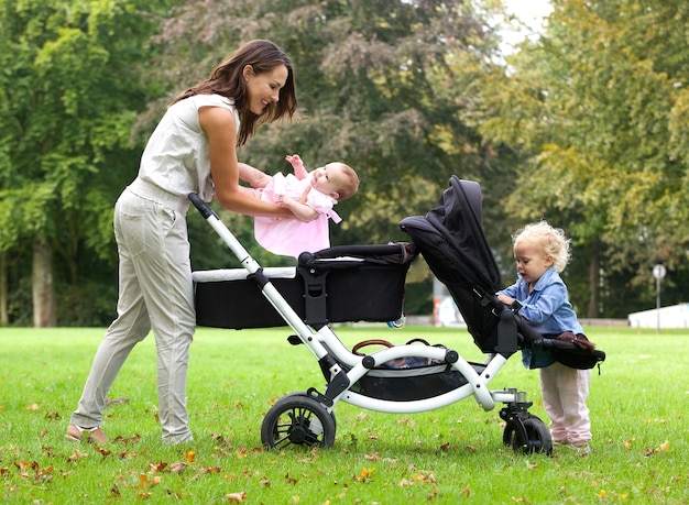 Madre e hijas con cochecito de niño al aire libre