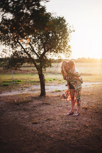 Madre e hijo abrazándose en la puesta de sol