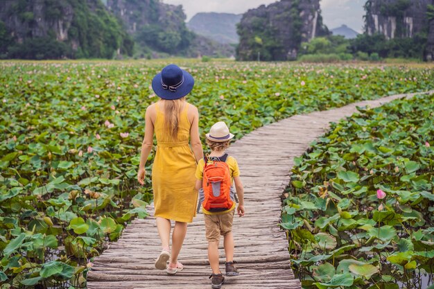 Madre e hijo en amarillo en el camino entre el lago lotus mua cueva ninh binh vietnam vietnam