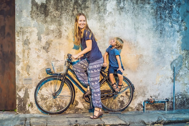 Madre e hijo en bicicleta. Bicicleta de la calle pública en Georgetown, Penang, Malasia