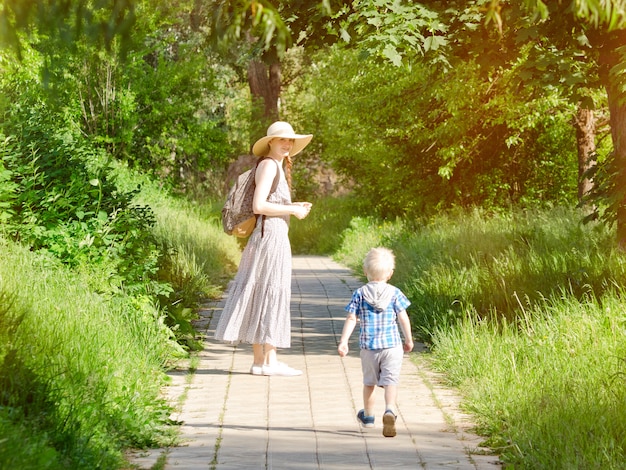 Madre e hijo caminando por la carretera en el parque.