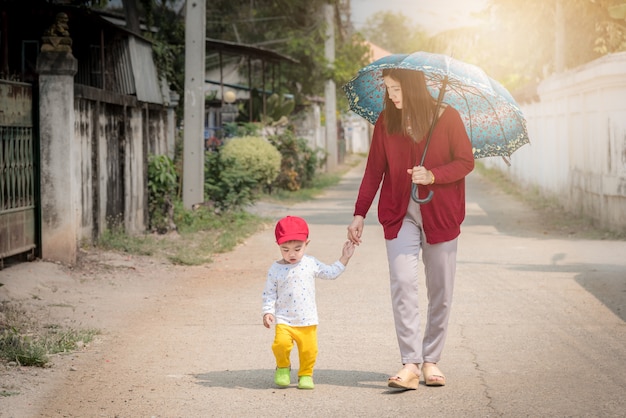 Madre e hijo caminando en la carretera