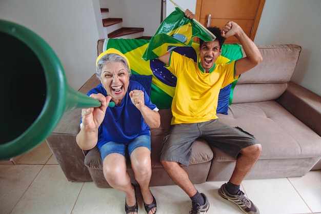 Madre e hijo celebrando la Copa en el salón viendo la televisión animando a Brasil