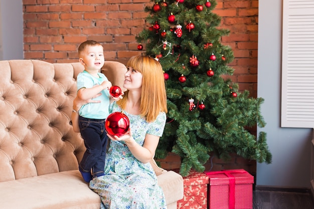 Madre e hijo cerca del árbol de Navidad.