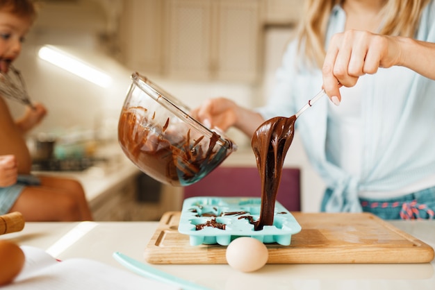 Foto madre e hijo cocinando y gustos chocolate derretido