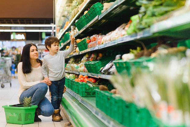 Madre e hijo comprando frutas en un mercado de agricultores