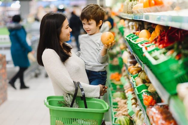 Madre e hijo comprando frutas en un mercado de agricultores