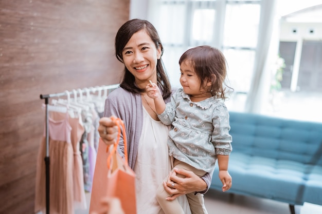 Madre e hijo comprando ropa en el centro comercial. feliz madre e hija en la tienda