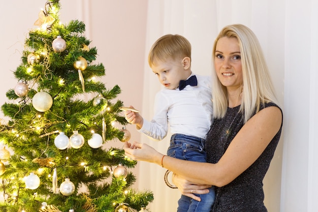 Madre e hijo decorando el árbol de navidad