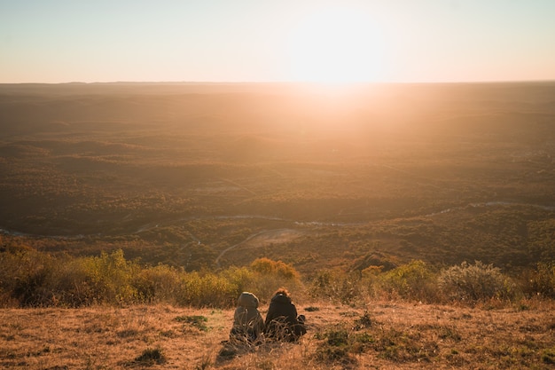 Madre e hijo disfrutando del atardecer en las montañas