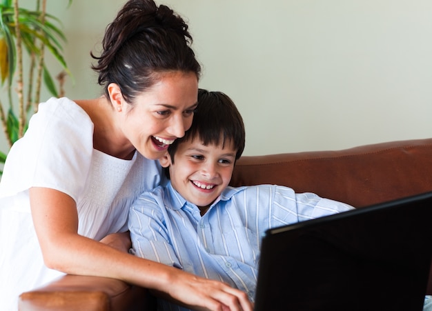 Madre e hijo se divierten con una computadora portátil