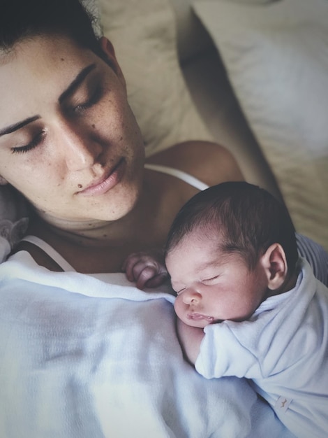 Foto madre e hijo durmiendo en la cama en casa