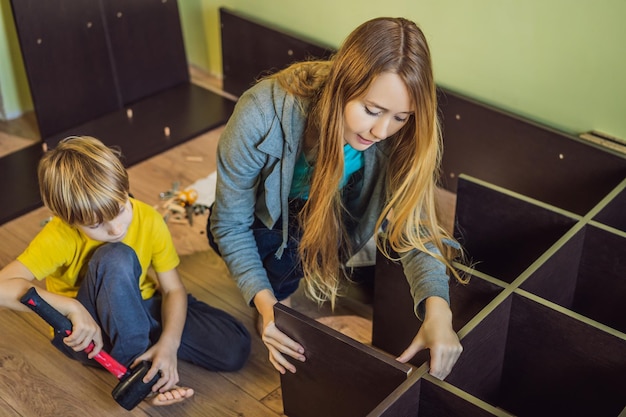 Madre e hijo ensamblando muebles Niño ayudando a su madre en casa Concepto de familia feliz