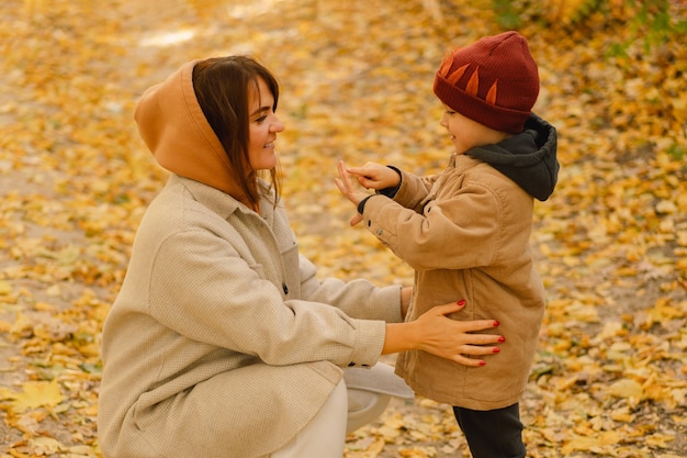 Madre e hijo están caminando en el bosque de otoño Actividad al aire libre de otoño para familias con niños