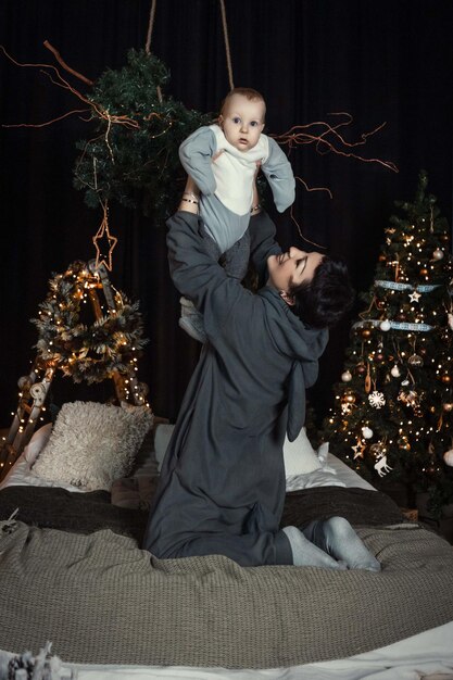 madre e hijo en el fondo del árbol de Navidad con disfraces de kigurumi