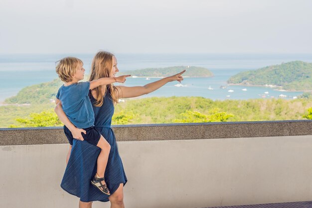 Madre e hijo en el fondo del panorama del paisaje de playa tropical hermoso océano turquesa