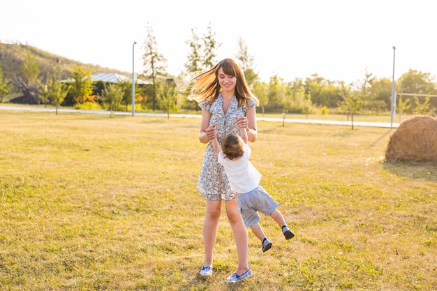 Madre e hijo girando en el parque de verano u otoño.