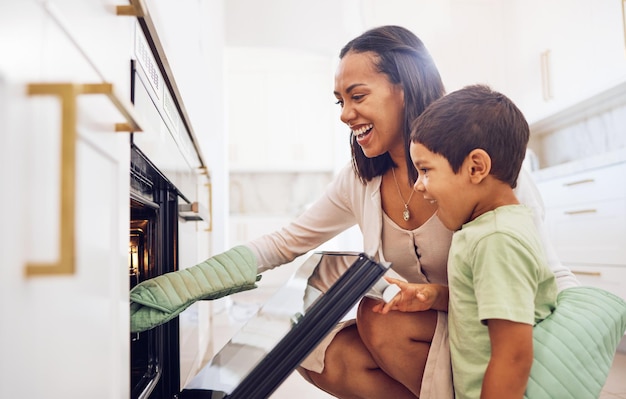 Madre e hijo y horneando en el horno aprendiendo a hacer galletas o pasteles en la cocina de la casa Apoyo para el cuidado o amor de los padres felices que unen la cocina o enseñan a los niños a hornear postres en la estufa juntos