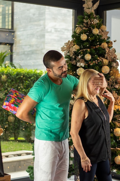 madre e hijo intercambiando regalos celebrando el día de navidad