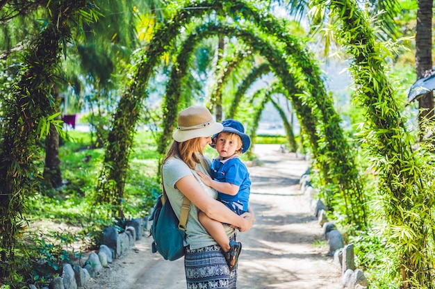 Madre e hijo en un jardín tropical