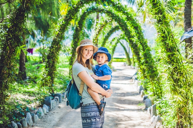 Madre e hijo en un jardín tropical