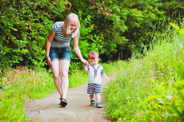 Madre e hijo juegan en el parque y se ríen en un paseo de verano en un día soleado. Vacaciones familiares