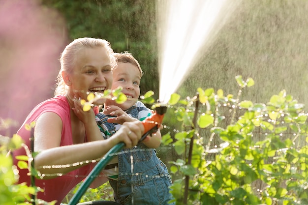 Madre e hijo jugando con agua