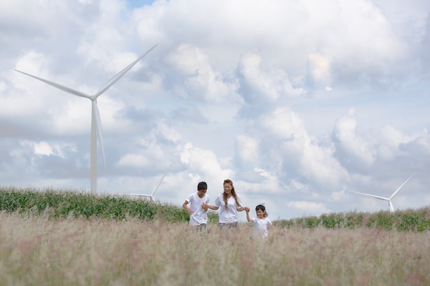 Madre e hijo jugando en archivado con una enorme turbina eólica en segundo plano.