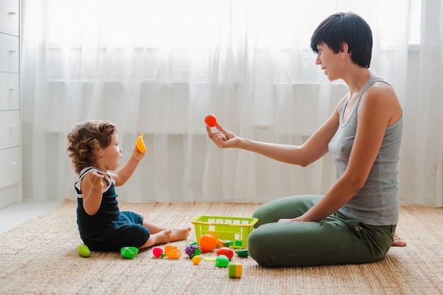 Madre e hijo jugando en el piso