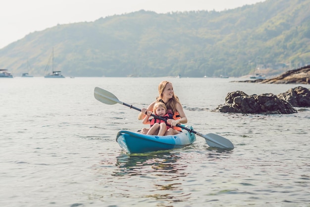 Madre e hijo en kayak en el océano tropical.