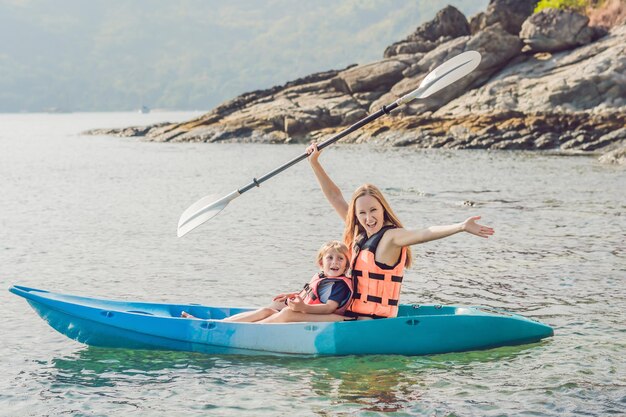 Madre e hijo en kayak en el océano tropical.