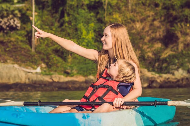 Madre e hijo en kayak en el océano tropical.