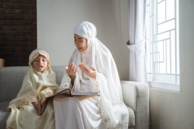 Madre e hijo leyendo el Corán