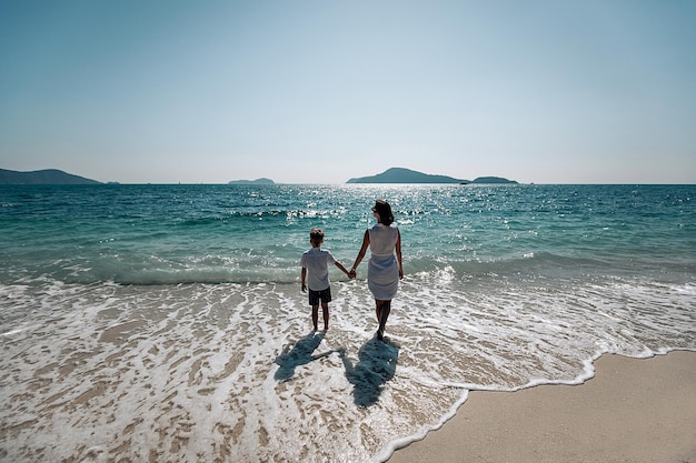 Madre e hijo miran juntos el mar. Mamá toma la mano de su hijo. Vista trasera. Concepto de vacaciones de verano en el mar. Phuket. Tailandia