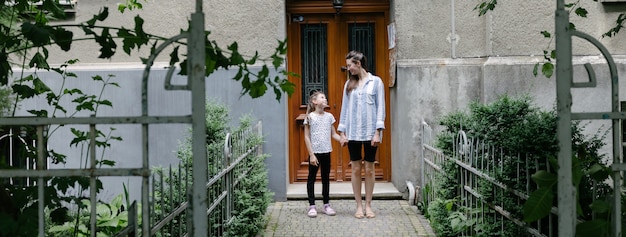 Madre e hijo mirándose junto a la entrada de una casa