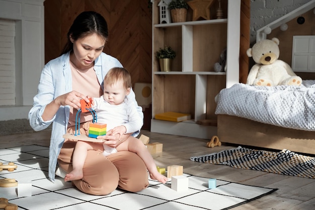 Madre e hijo modernos jugando con juguetes.