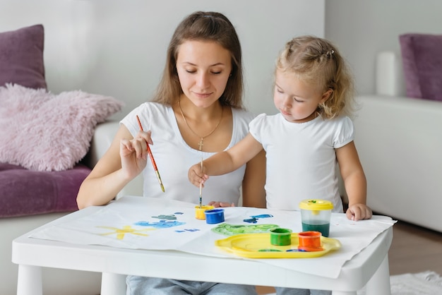 Madre e hijo niño pintando en casa