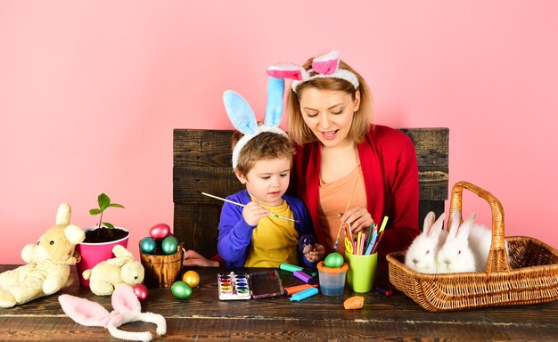 Madre e hijo pintando huevos de pascua