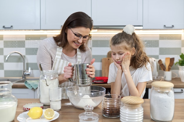 Madre e hijo preparando panadería juntos en la cocina de casa